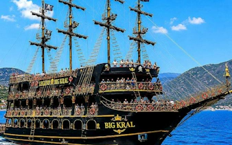 Pirate-themed boat with tourists on deck, Alanya coast, Turkey.