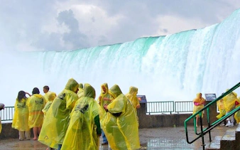 Tourists in yellow ponchos near Niagara Falls on a guided vehicle tour.