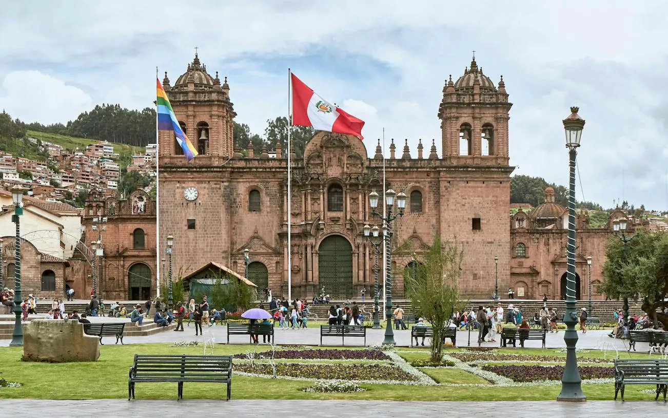 Cusco Cathedral with flags in Plaza de Armas, part of the Cusco Historic Center walking tour.