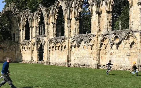 York walking tour with visitors playing games near medieval ruins.