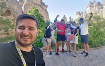 Group enjoying Cappadocia Red Tour with rock formations in the background.