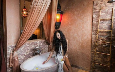 Authentic Moroccan hammam with ornate lanterns and a marble tub in Marrakesh.