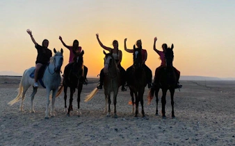 Horseback riders in desert at sunset, Sharm El Sheikh tour.