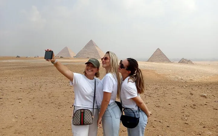 Tourists taking a selfie with the Giza Pyramids in the background, Egypt.