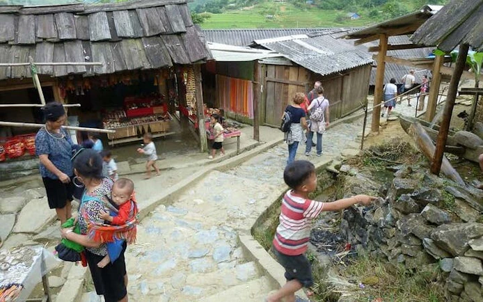 Local villagers and tourists walking through Cat Cat Village in Sa Pa, Vietnam.