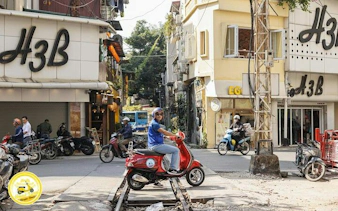 Vespa rider on Hanoi street near Bat Trang Ceramic Village tour route.