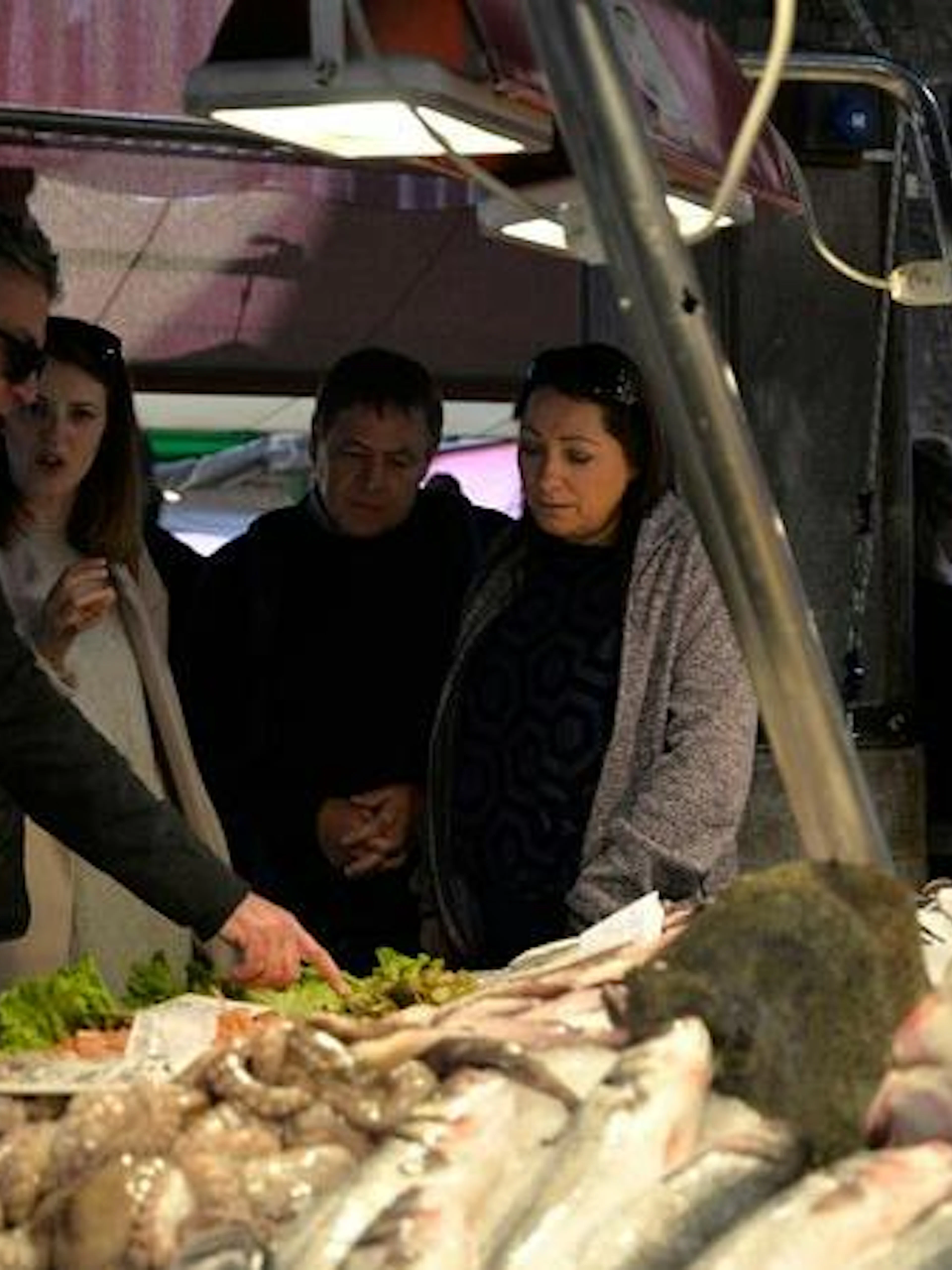 Tour group exploring seafood at Rialto Market, Venice.
