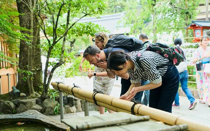 Visitors exploring a traditional bamboo water feature in Kyoto's Gion district.