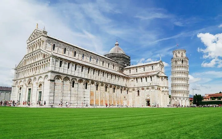 Leaning Tower of Pisa and Pisa Cathedral under blue sky, Italy.