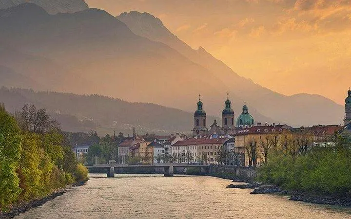 Innsbruck cityscape with river and mountains at sunset, viewed from Salzburg day trip.