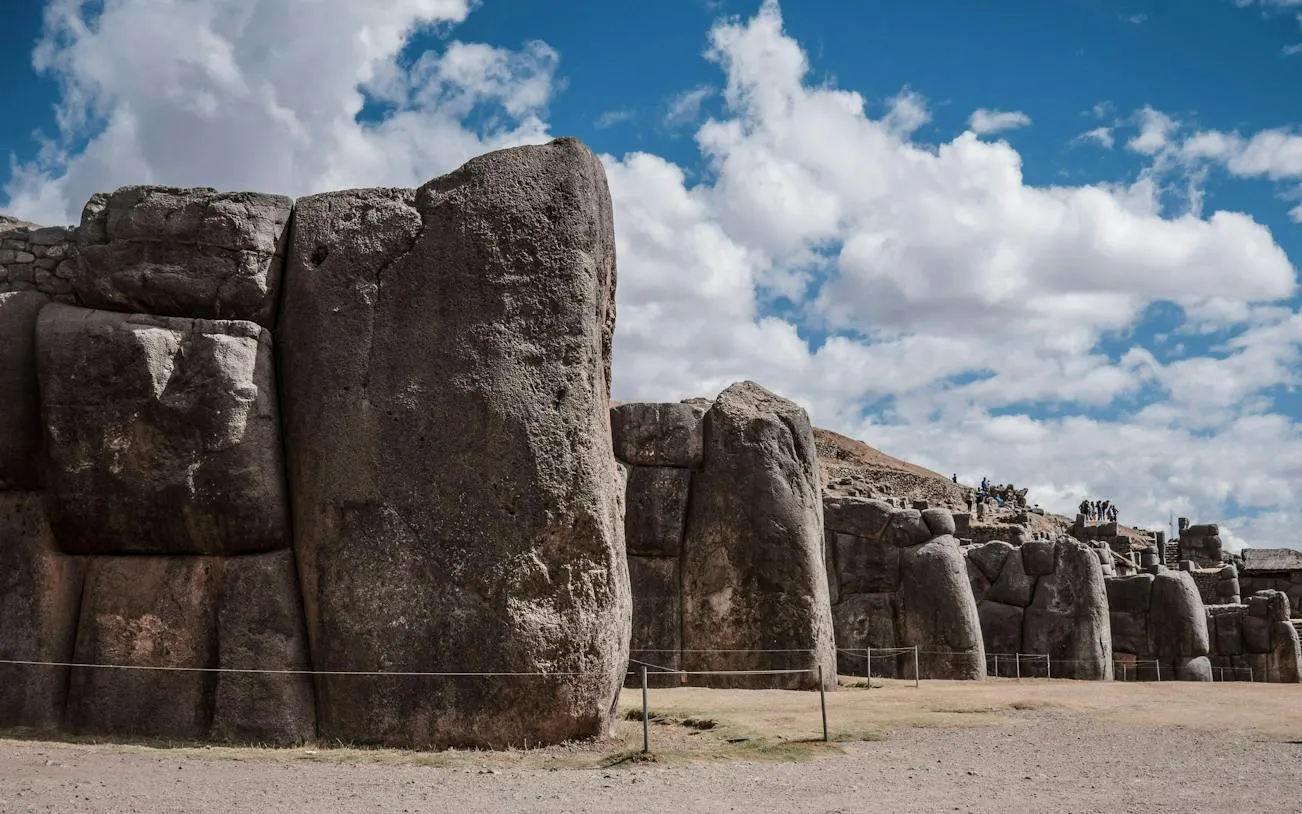 Sacsayhuamán stone walls under a cloudy sky in Cusco, Peru.