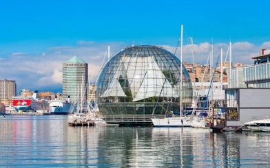 Genoa harbor with glass biosphere and boats, featured in self-guided walking tour app.