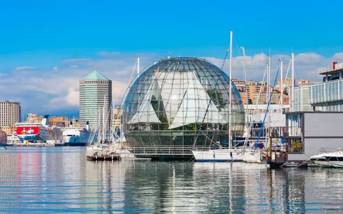 Genoa harbor with glass biosphere and boats, featured in self-guided walking tour app.