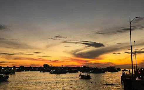 Sunset view over boats at Puerto Baquerizo Moreno, Galapagos, for Kicker Rock snorkeling tour.