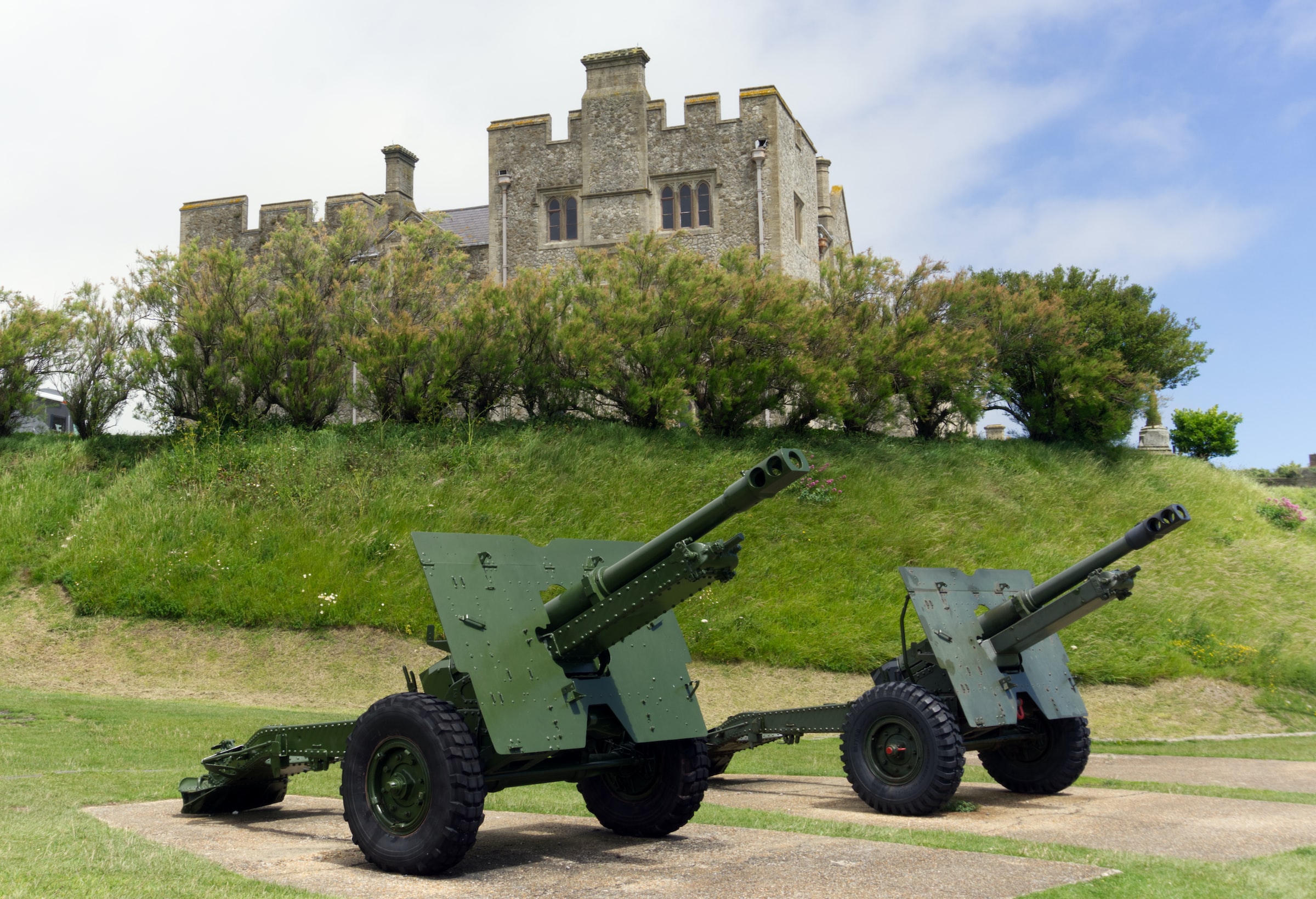 Cannons on display at Dover Castle, England, with historic stone structure in the background.