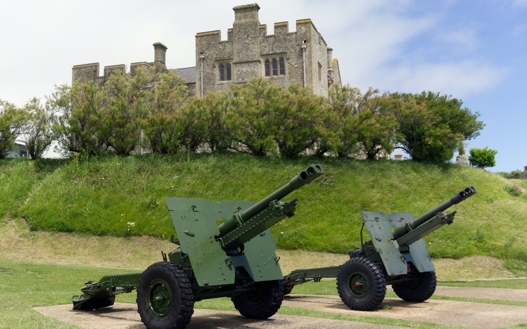 Cannons on display at Dover Castle, England, with historic stone structure in the background.