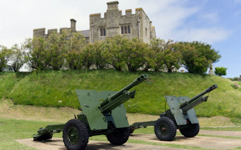 Cannons on display at Dover Castle, England, with historic stone structure in the background.
