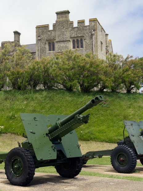Cannons on display at Dover Castle, England, with historic stone structure in the background.