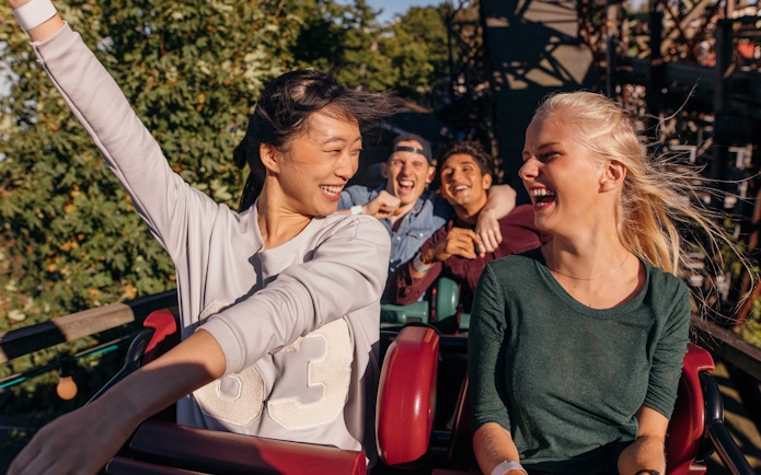 People enjoying a roller coaster ride at a theme park in Barcelona.