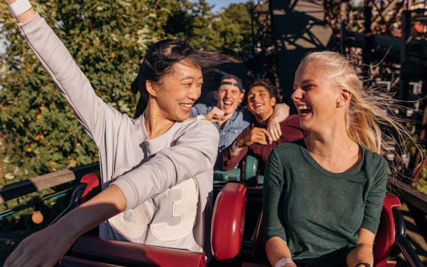 People enjoying a roller coaster ride at a theme park in Barcelona.