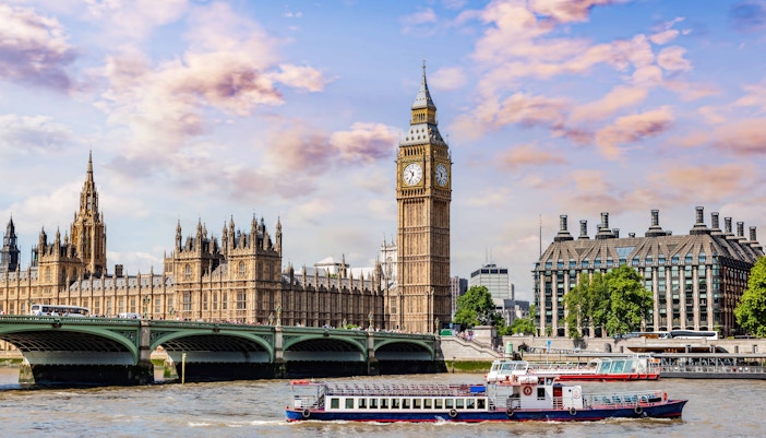 Thames River cruise boat passing by the London Eye and Big Ben, part of a 2-day unlimited tour.