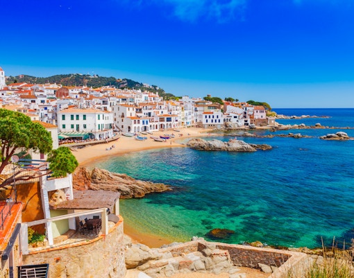 Coastal village with white buildings and beach in Costa Brava, Spain.