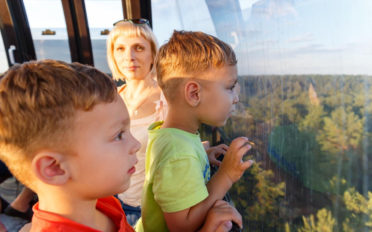 Children enjoying a scenic view from a cable car in Singapore.
