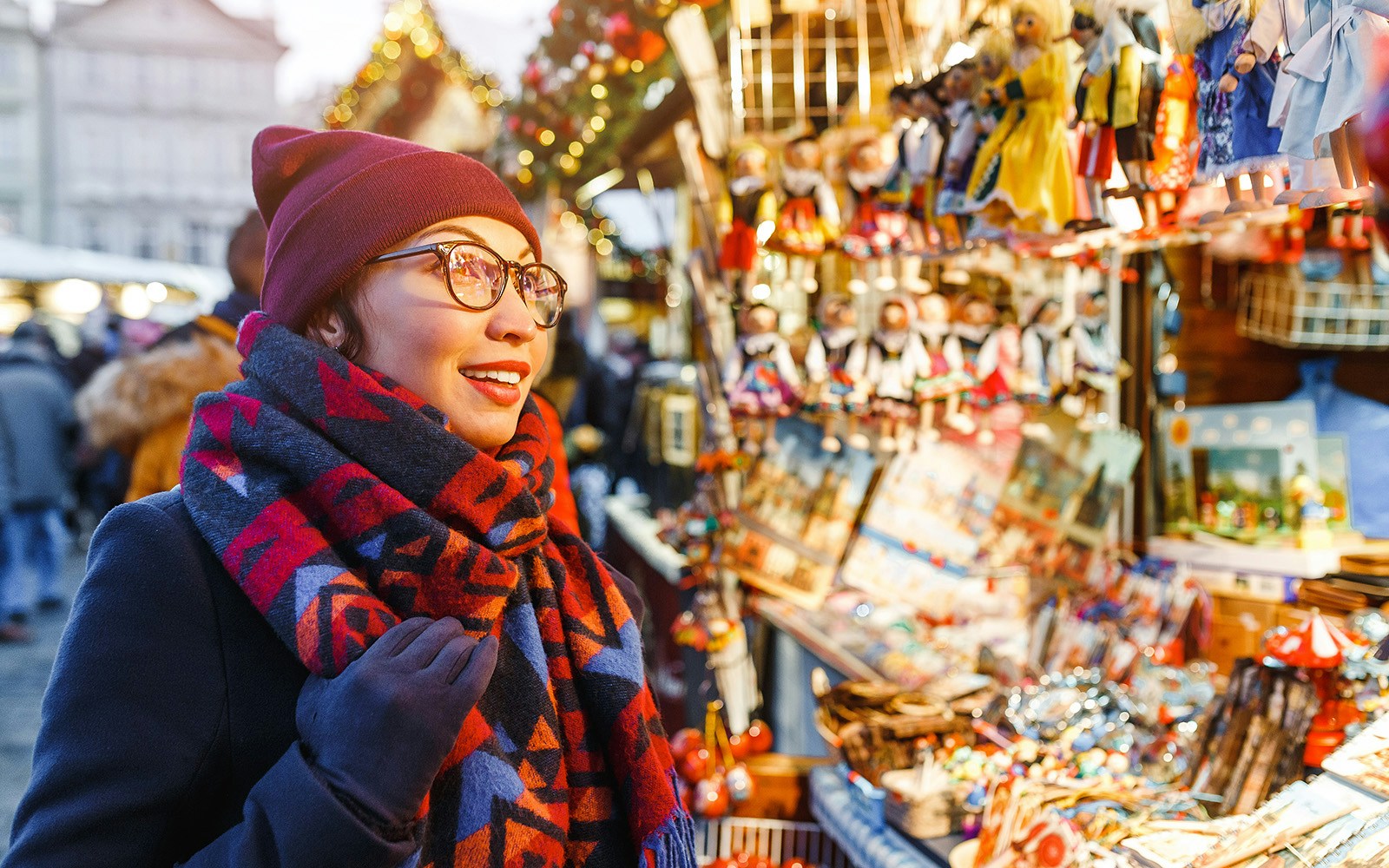 Shopper at Prague Christmas market browsing festive stalls.