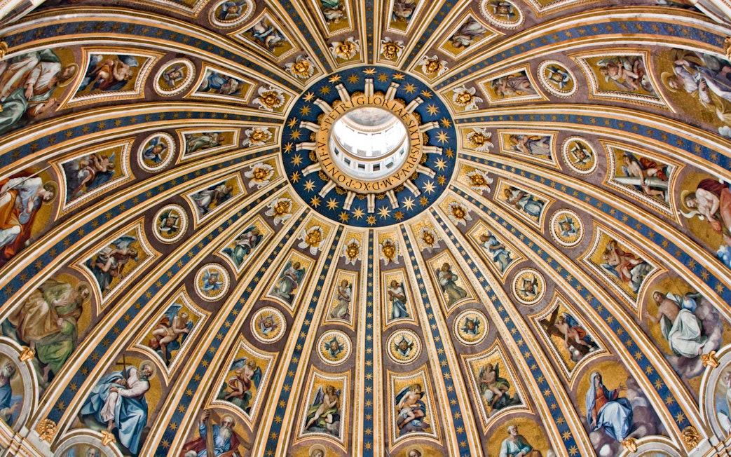 St. Peter's Basilica dome interior with intricate frescoes and gold detailing, Vatican City.