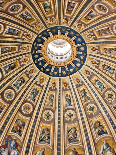 St. Peter's Basilica dome interior with intricate frescoes and gold detailing, Vatican City.
