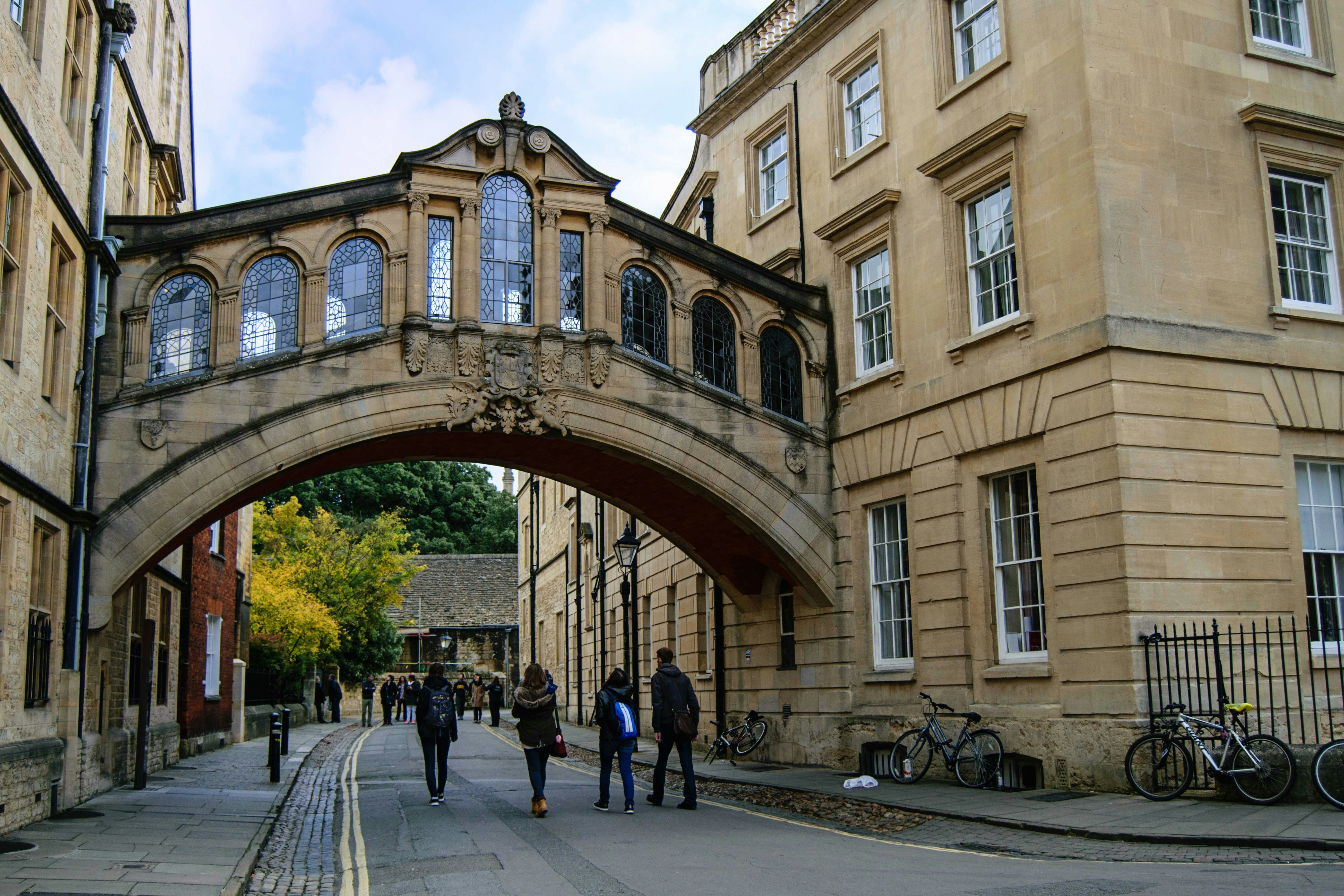 Pedestrians walking under the Bridge of Sighs in Oxford, England.