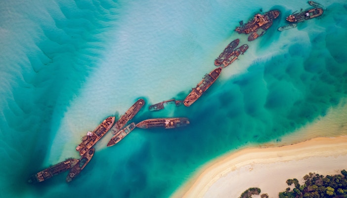Shipwrecks in turquoise waters near Moreton Island shoreline.