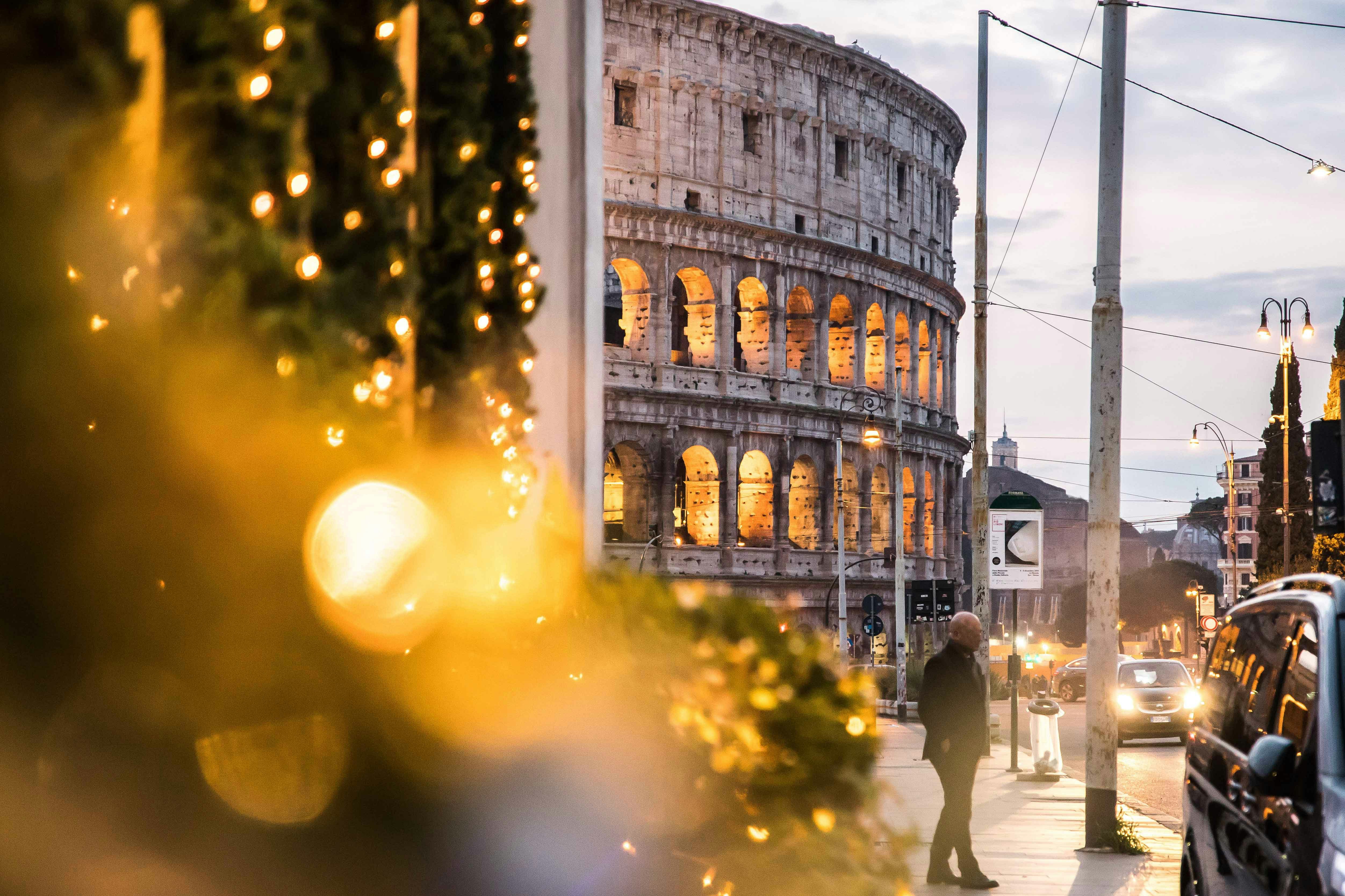 Colosseum in Rome with Christmas lights in foreground.