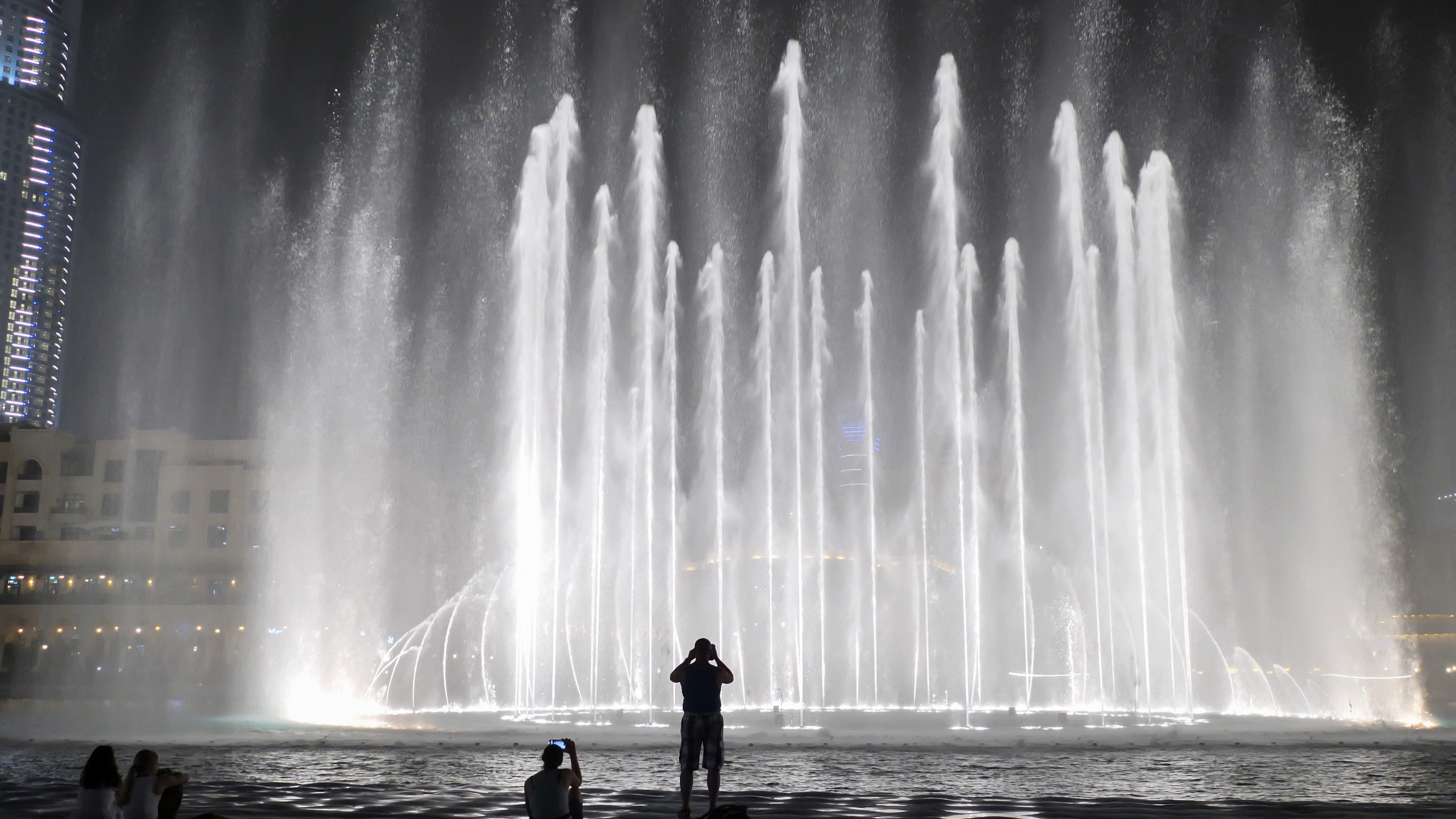 Dubai Fountain night show with water jets illuminated against the skyline.