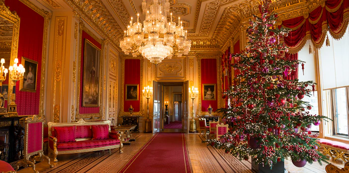 Windsor Castle state apartments interior with ornate chandelier and decorated Christmas tree.