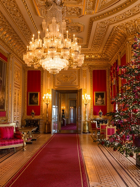 Windsor Castle state apartments interior with ornate chandelier and decorated Christmas tree.