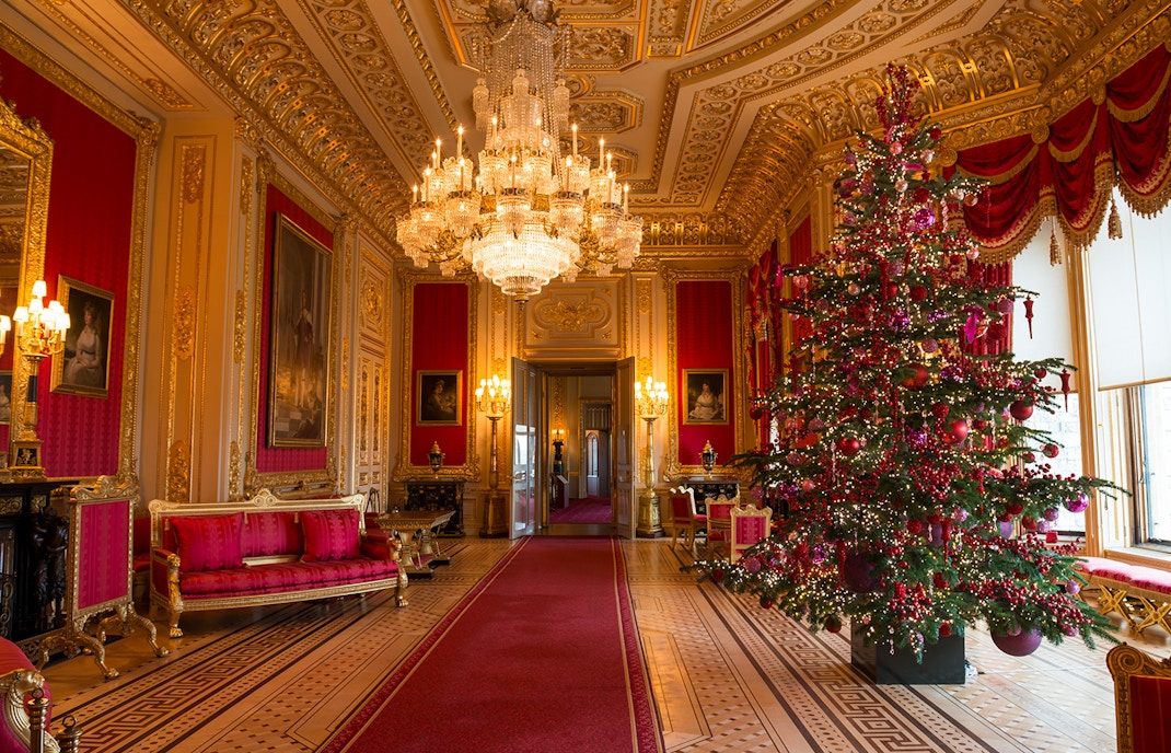 Windsor Castle state apartments interior with ornate chandelier and decorated Christmas tree.