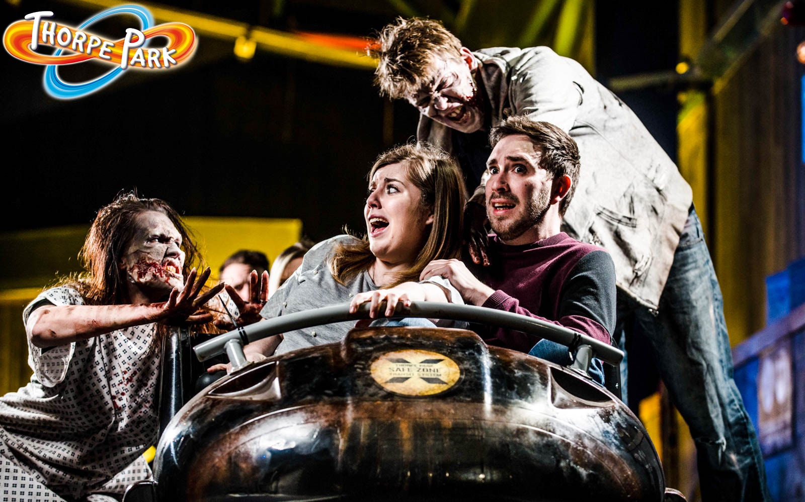 Visitors on a ride at Thorpe Park Resort with actors dressed as zombies.