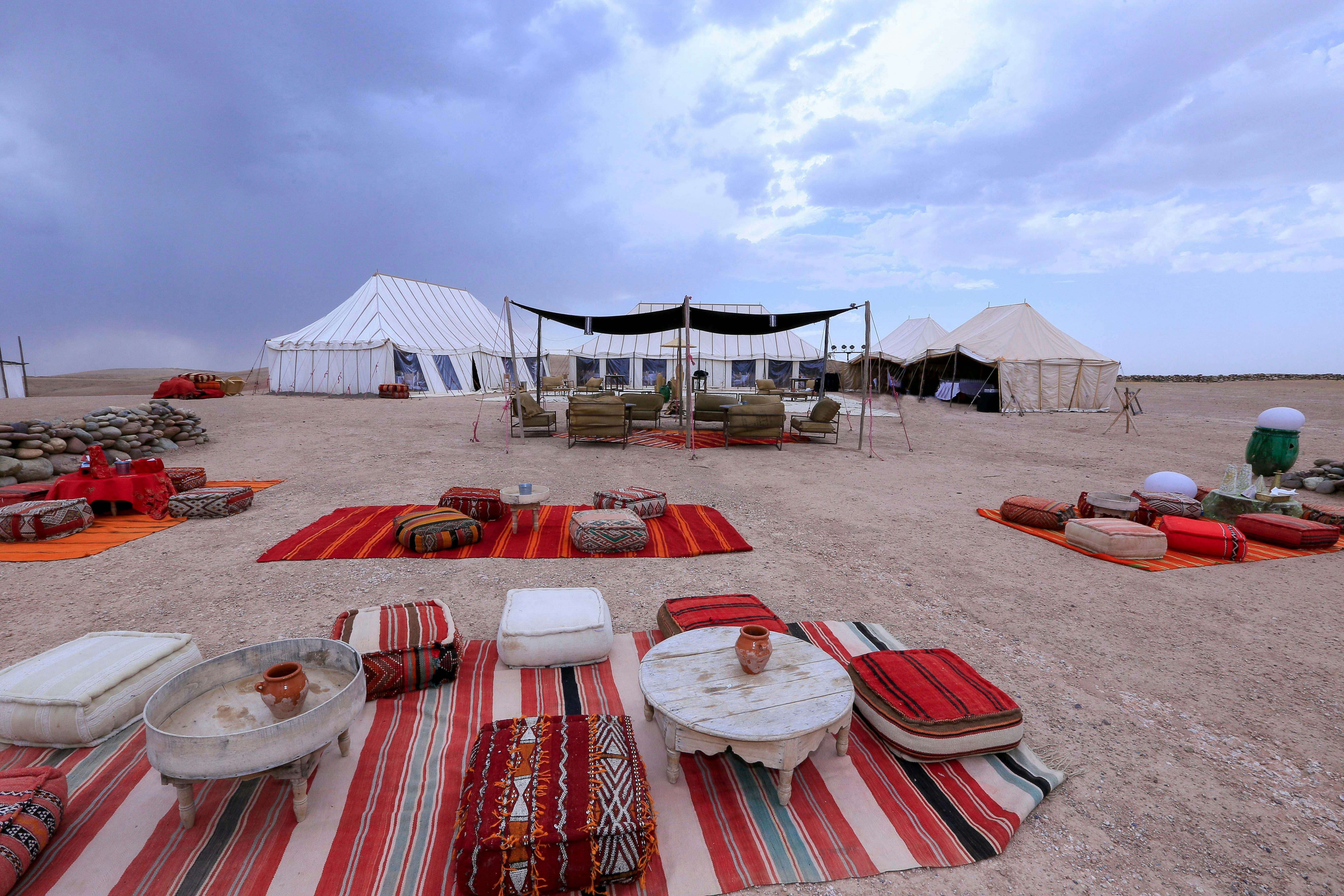 Desert camp setup with tents and seating in Agafay Desert, Marrakesh.