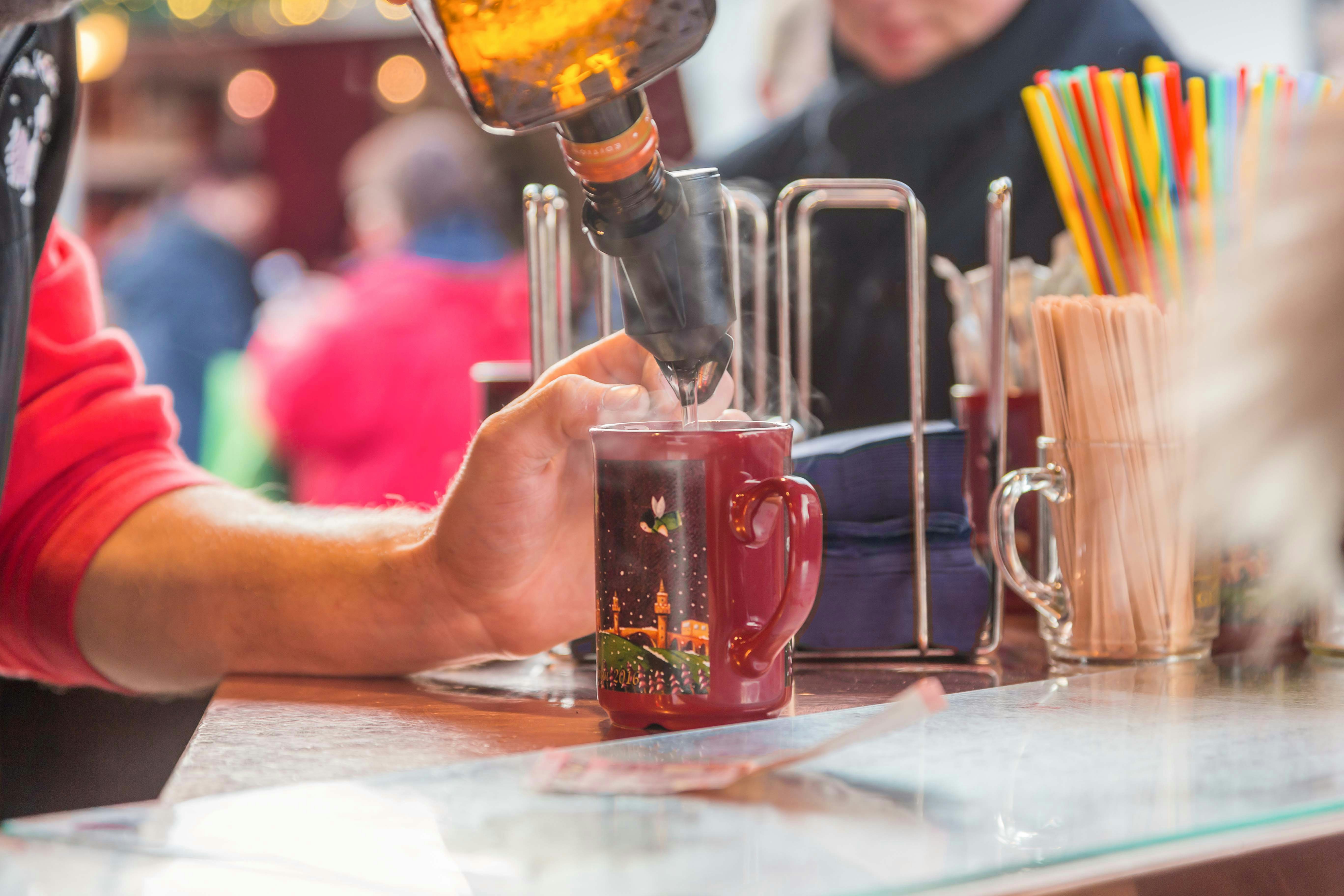 Pouring mulled wine into a festive mug at a Berlin Christmas market.