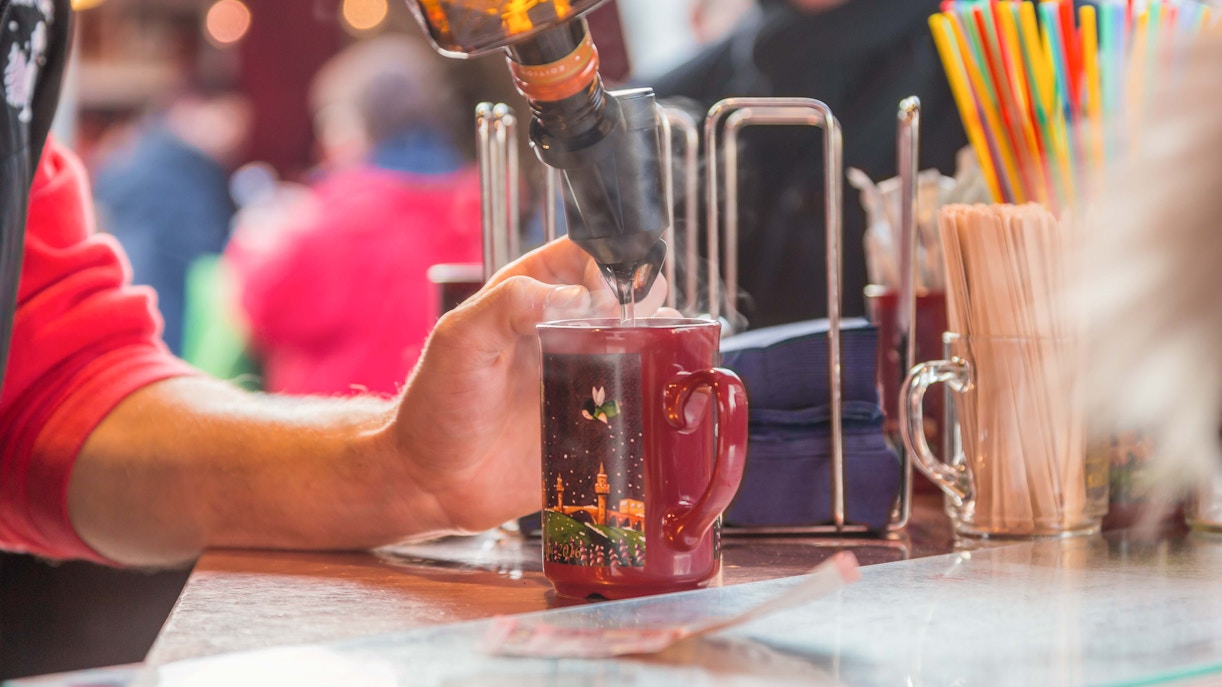 Pouring mulled wine into a festive mug at a Berlin Christmas market.