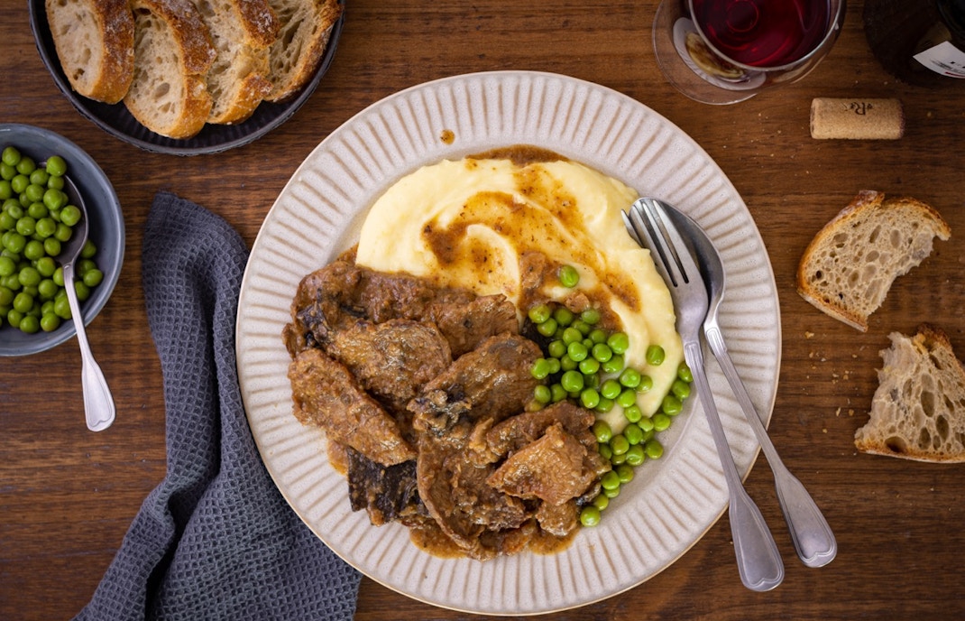Traditional Catalan cuisine dishes displayed on a wooden table in Barcelona, Spain.