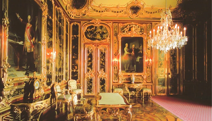 Schonbrunn Palace interior with ornate gold decor and chandeliers, Vienna.