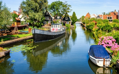 Canal view in Volendam with boats and traditional Dutch houses.