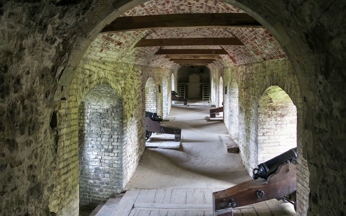 Dover Castle Secret Wartime Tunnels with historic cannons and arched brick passageways.