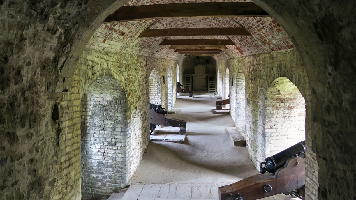 Dover Castle Secret Wartime Tunnels with historic cannons and arched brick passageways.
