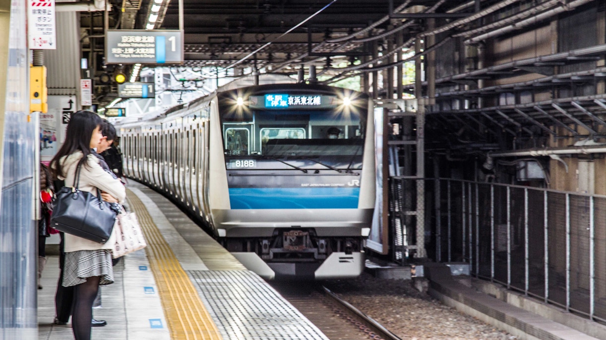 Train arriving at a platform in Japan, passengers waiting, Universal Studios Japan access.