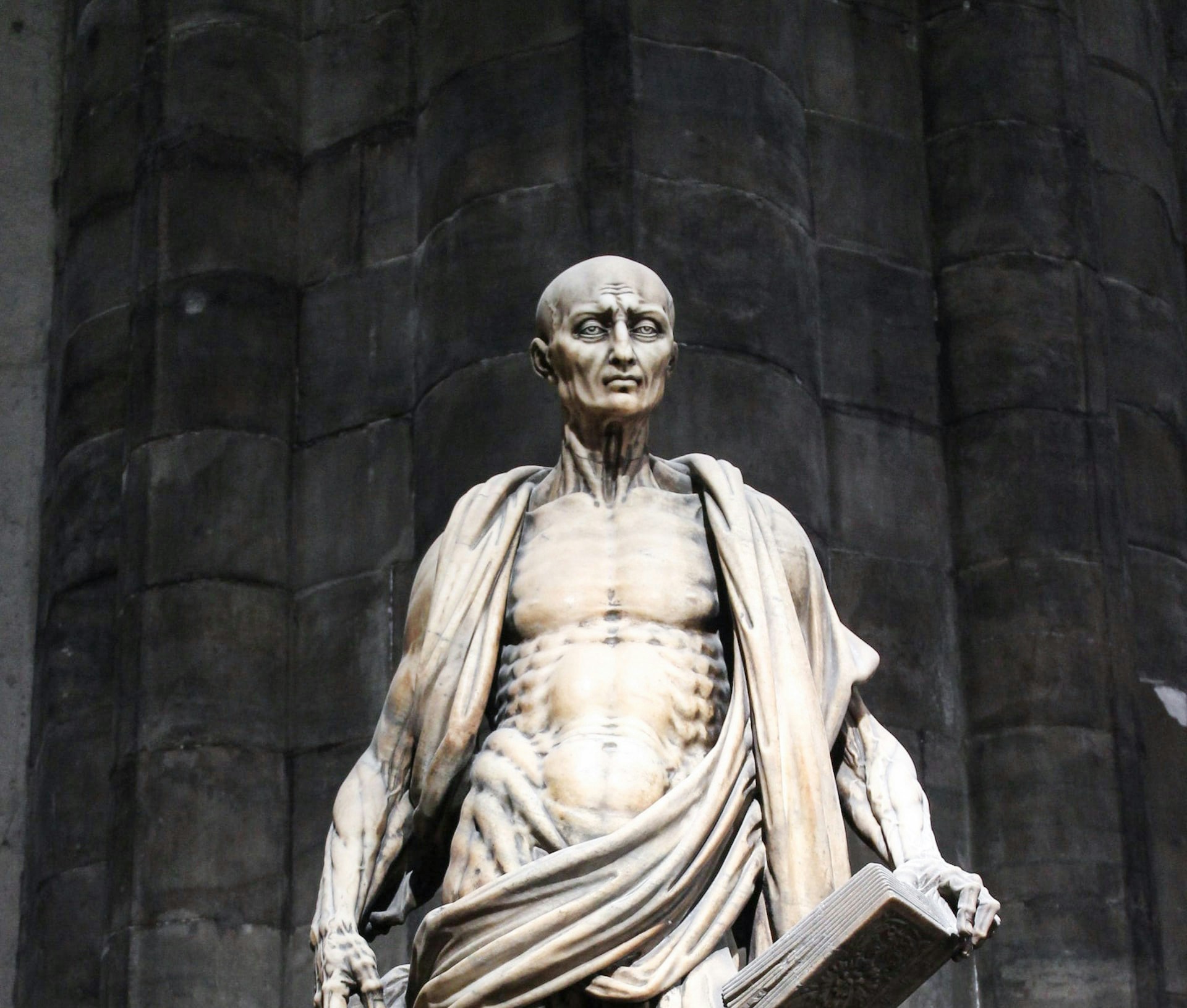 Statue of Saint Bartholomew holding a book at Duomo Milan.