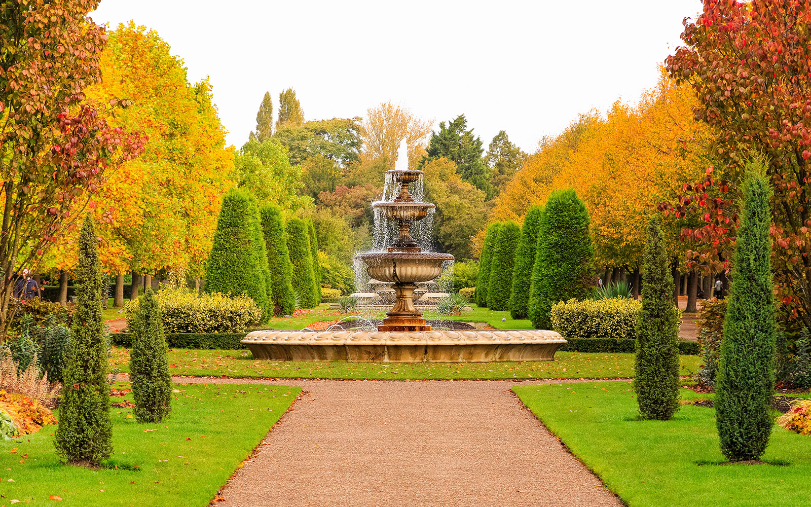 Fountain in a landscaped garden with autumn trees, London.