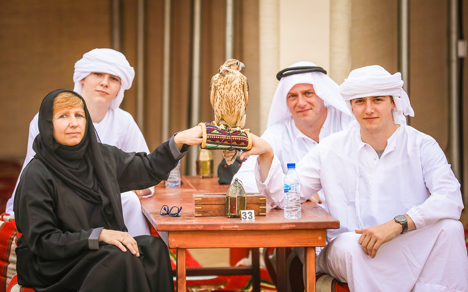 Group enjoying falconry at Dubai desert safari Bedouin experience.